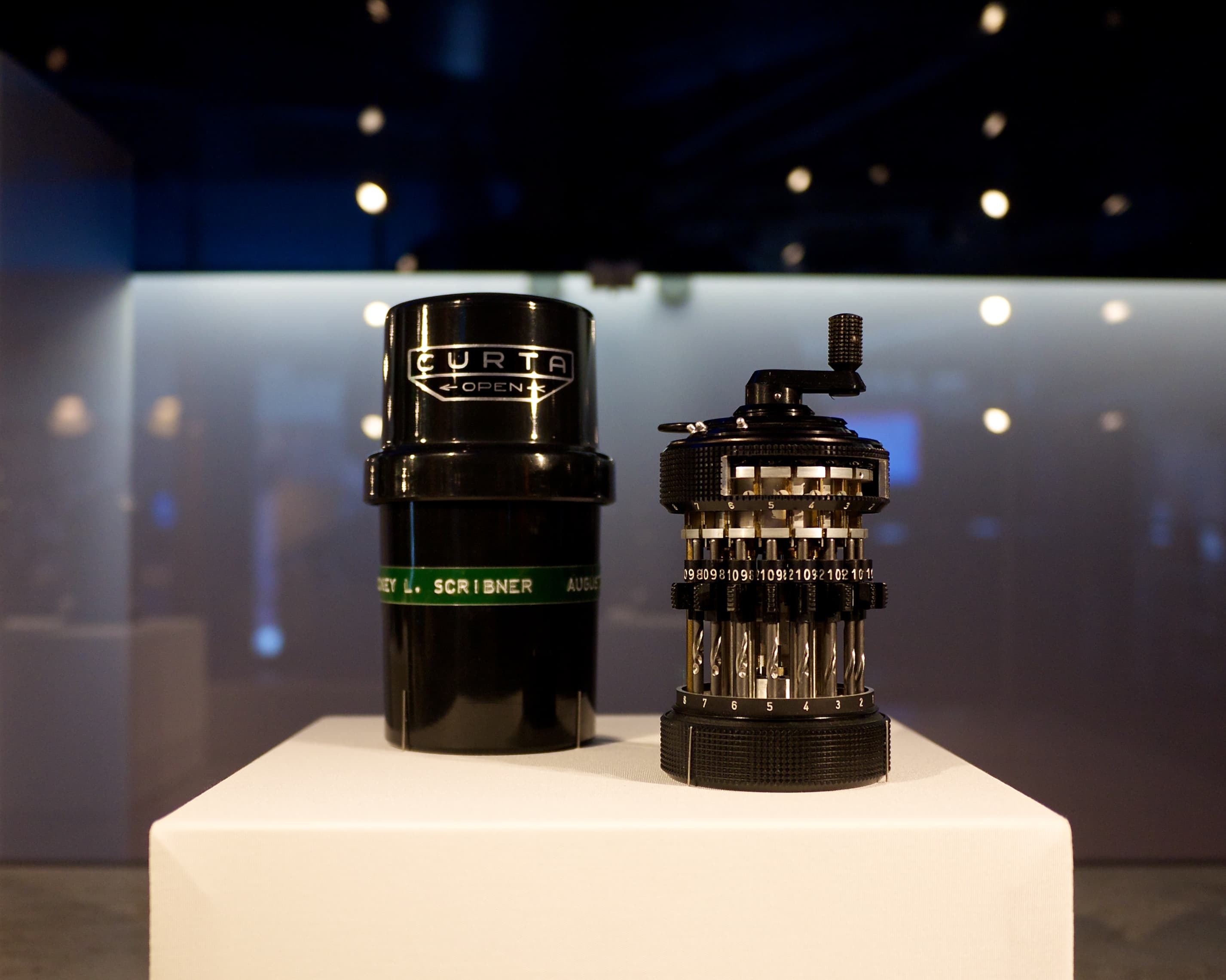 Curta calculator displayed with its case and exposed mechanism