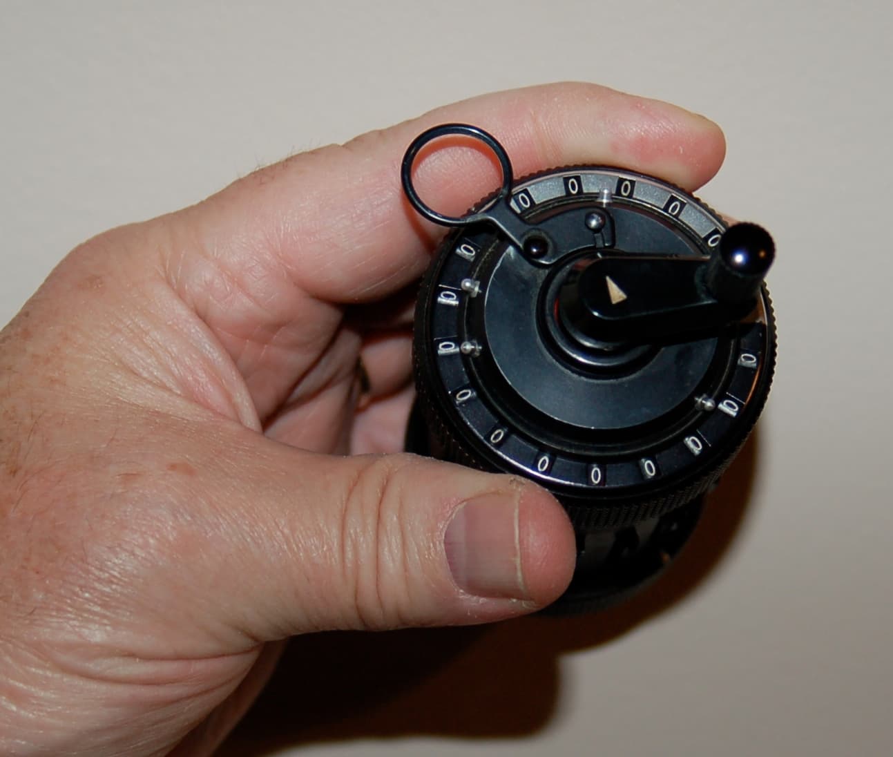Top view of a Curta calculator showing the crank and register windows